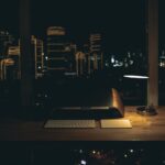 A lit desk lamp on a dark desk
