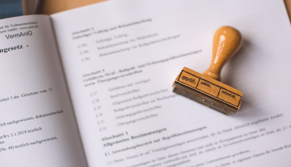 A wooden rubber stamp resting on an open legal document